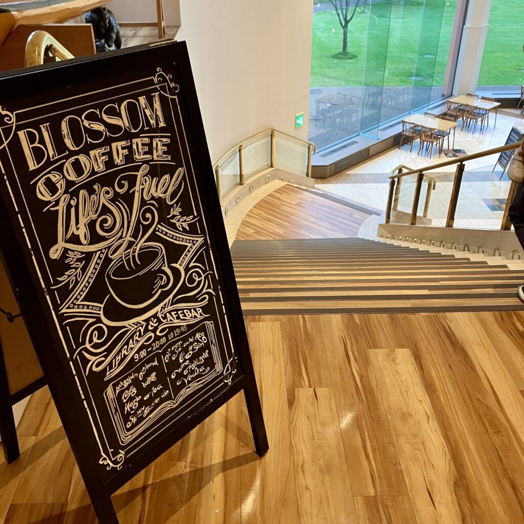 Library＆Cafe BLOSSOM COFFEEと書かれた看板と店内へ続く階段