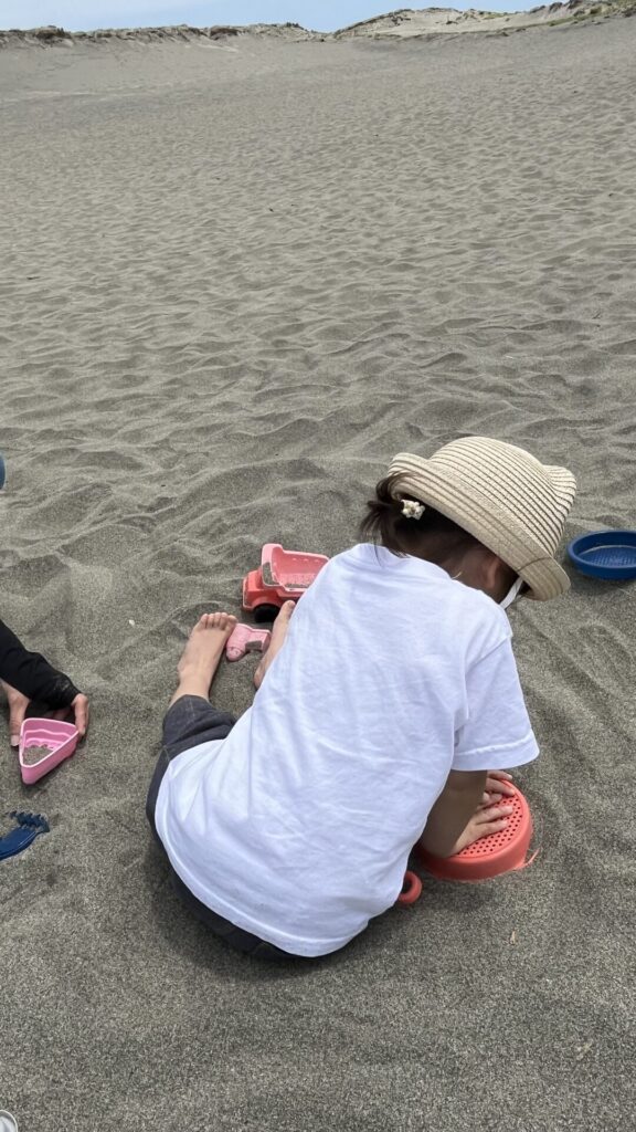 砂遊びをする娘