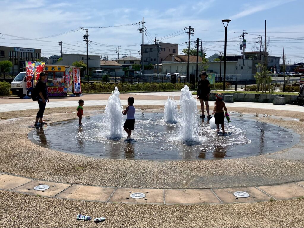 噴水広場で水遊びをする子ども達