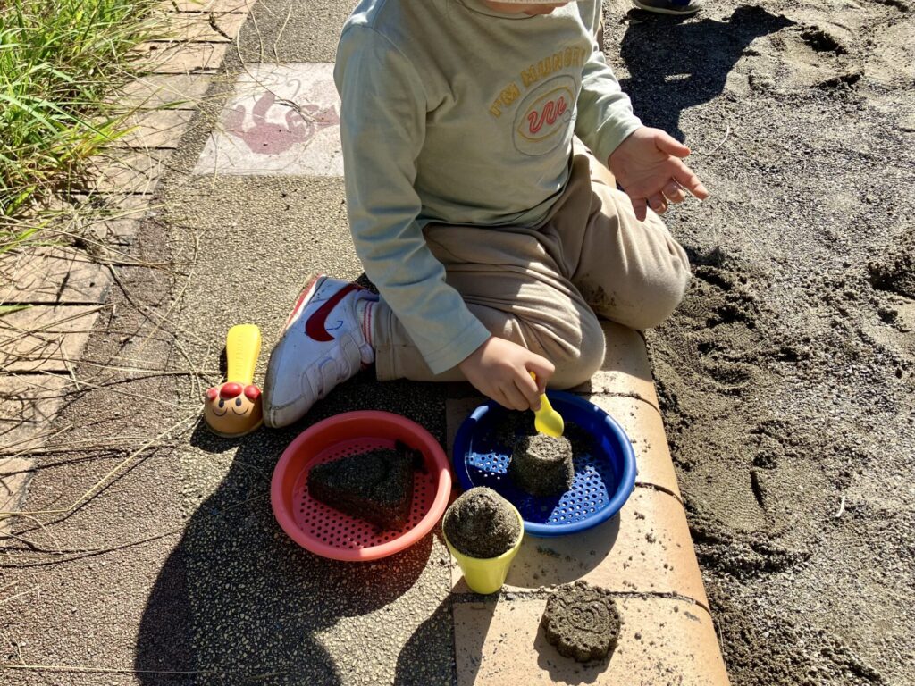 砂場で砂遊びをするむっちゃん