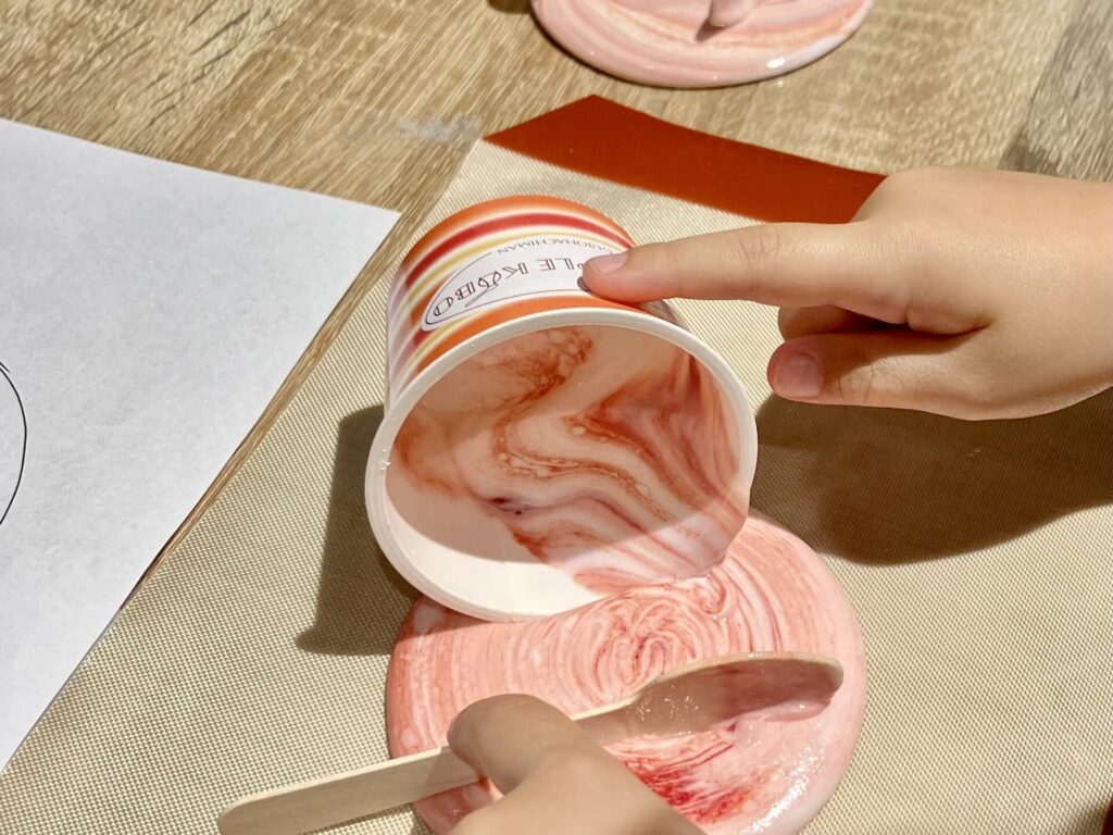 机に流したカップアイスを指で押さえて固定している様子