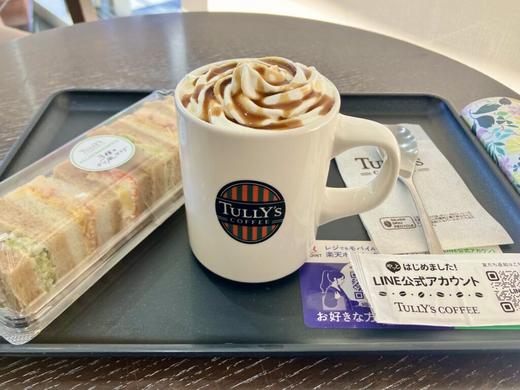 テーブルの上に置かれたタリーズのマグカップとサンドイッチ